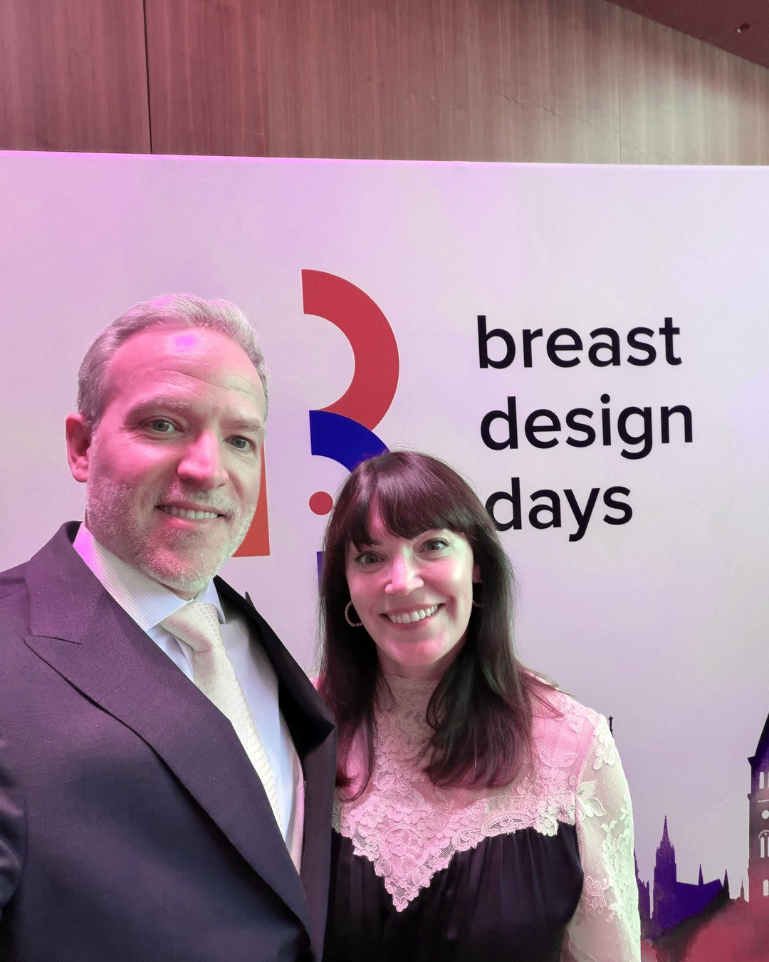 Dr. Nicholas Haddock and his wife, Emily, at the Breast Design Days backdrop in Łódź