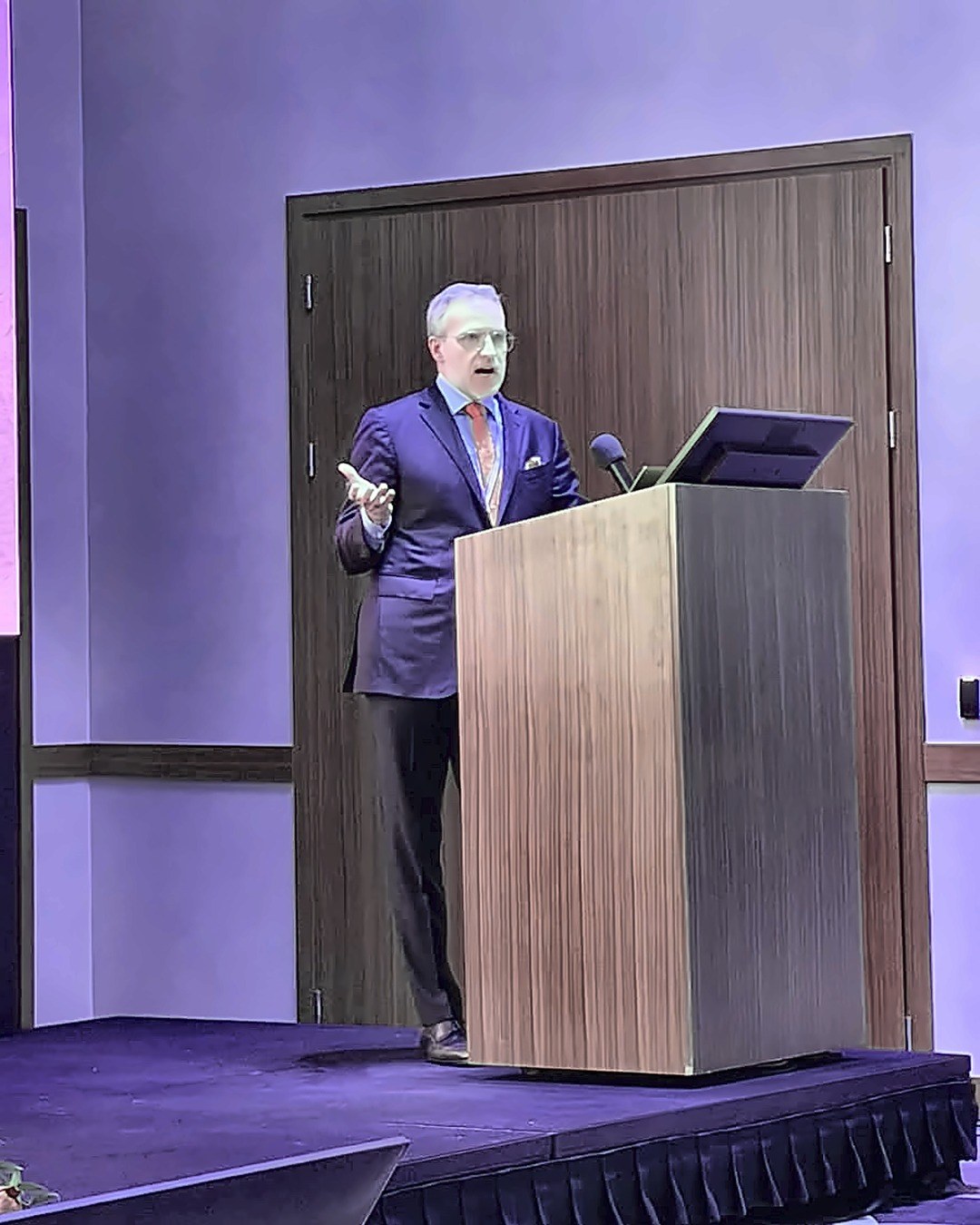 Dr. Nicholas Haddock speaking at the podium at Breast Design Days in Łódź, Poland
